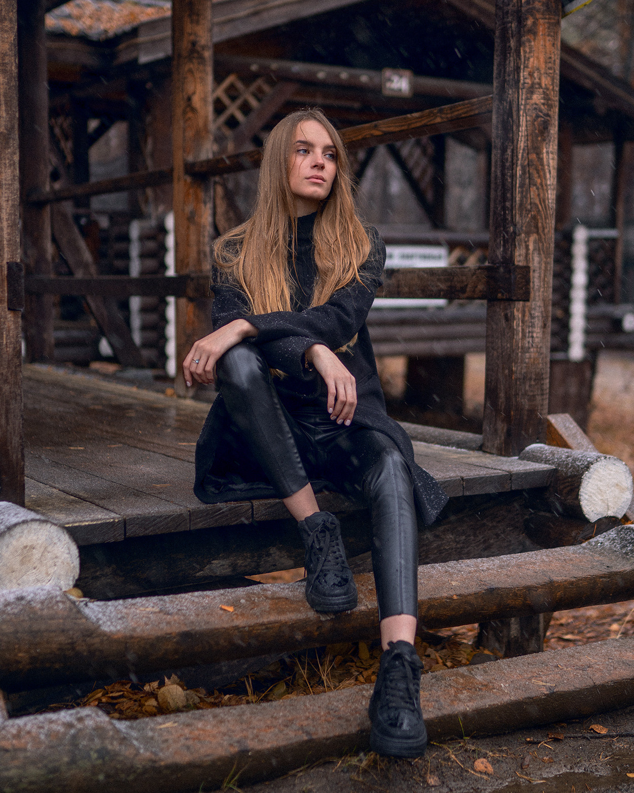 Женский портрет девушка в черном сидит на крыльце беседки и задумчиво смотрит