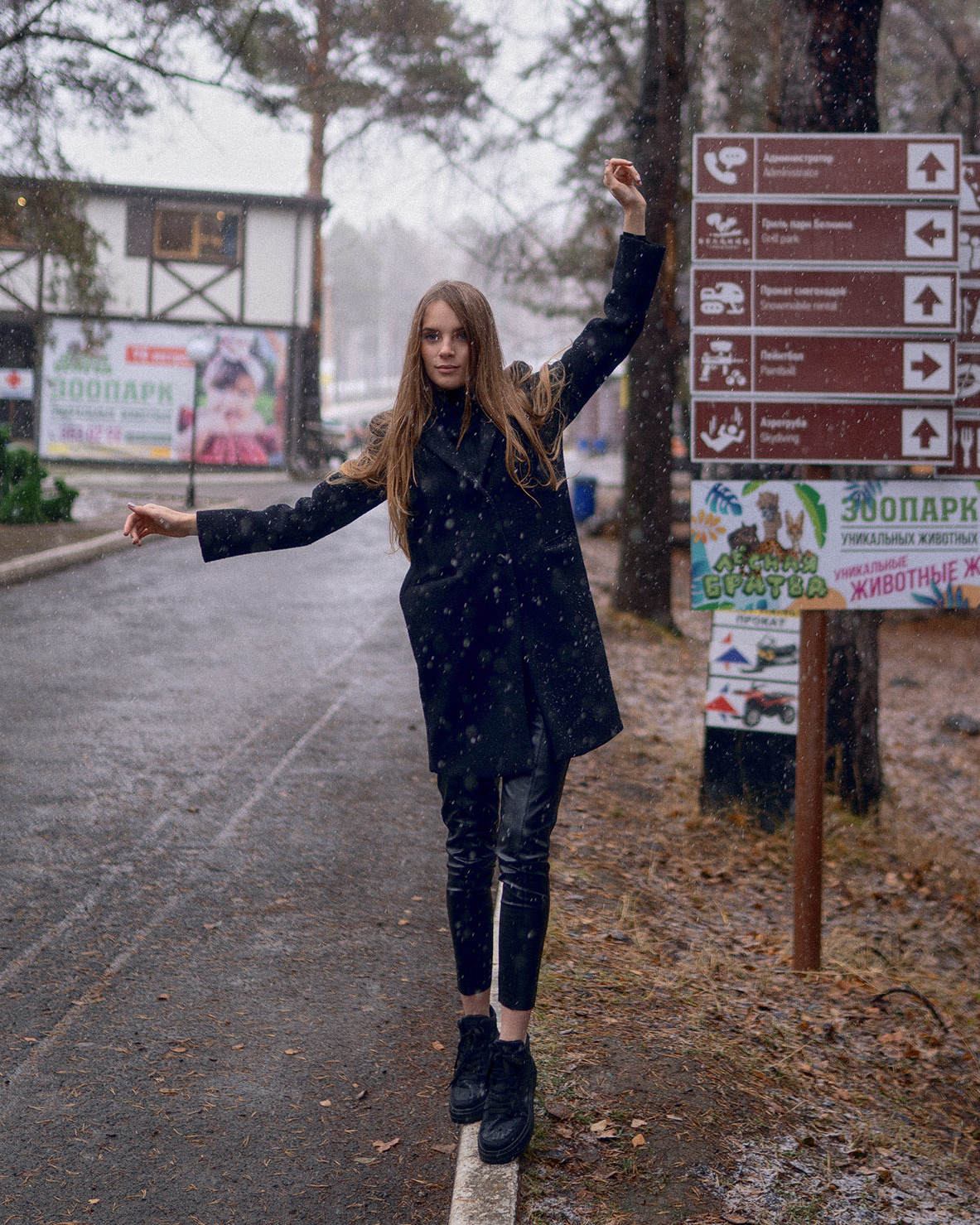 Девушка в черном идет по бордюру 