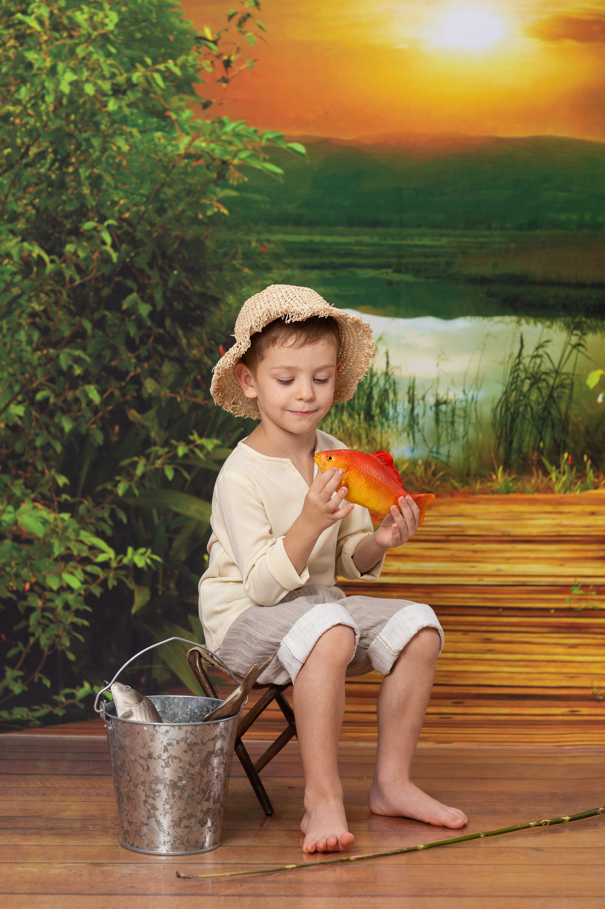 Детская тематическая костюмированная фотосессия Рыбачок. Ребенок поймал золотую рыбку.