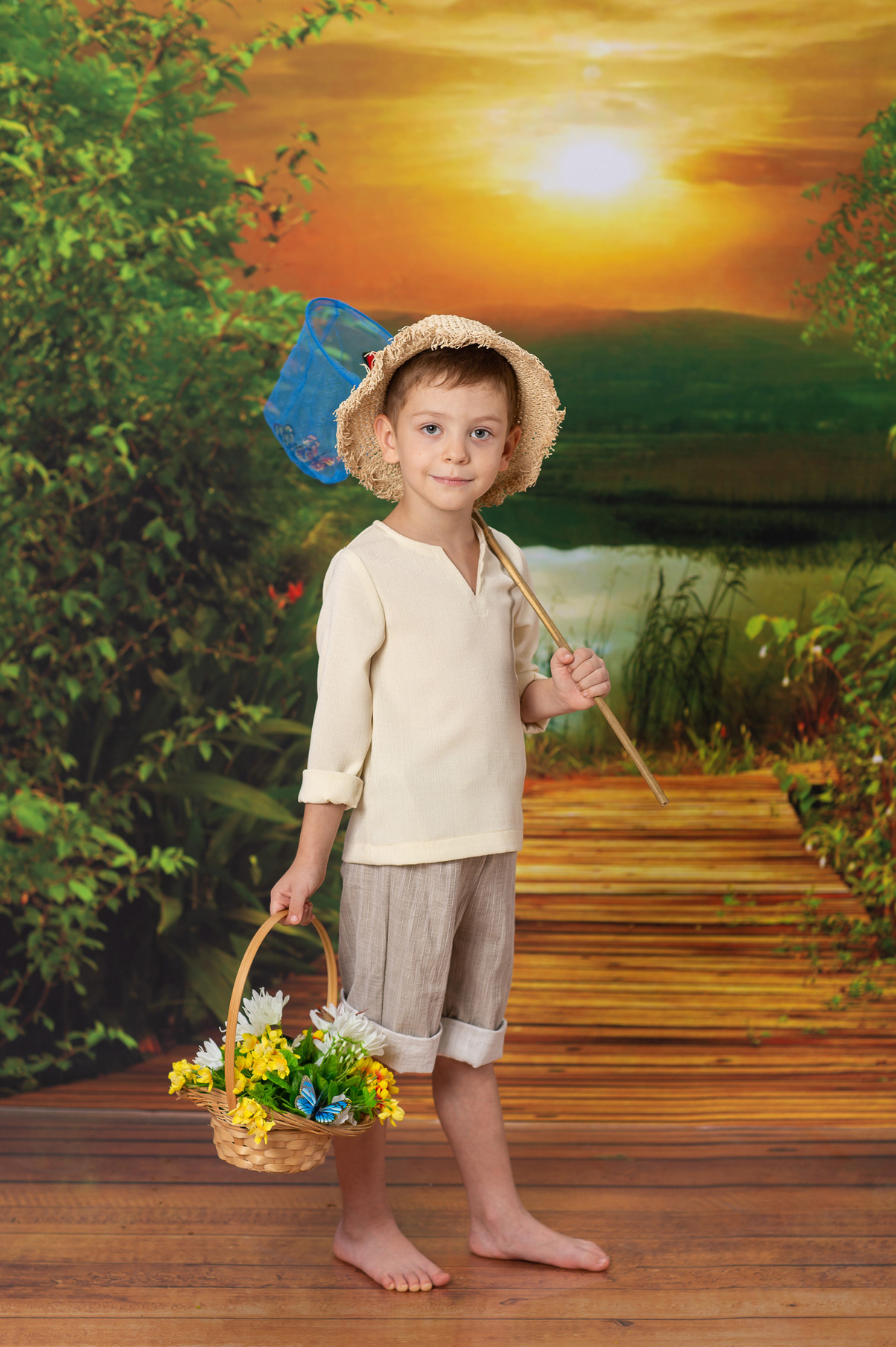 Детская тематическая костюмированная фотосессия Рыбачок.  Мальчик с сачком и корзинкой цветов.