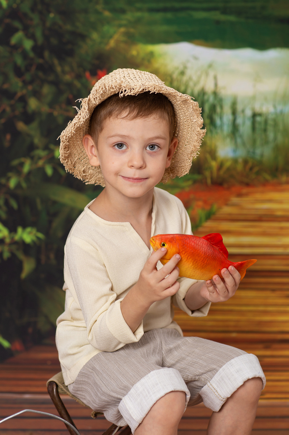 Детская тематическая костюмированная фотосессия на рыбалке. Портрет мальчика с фотосессии в детском саду.