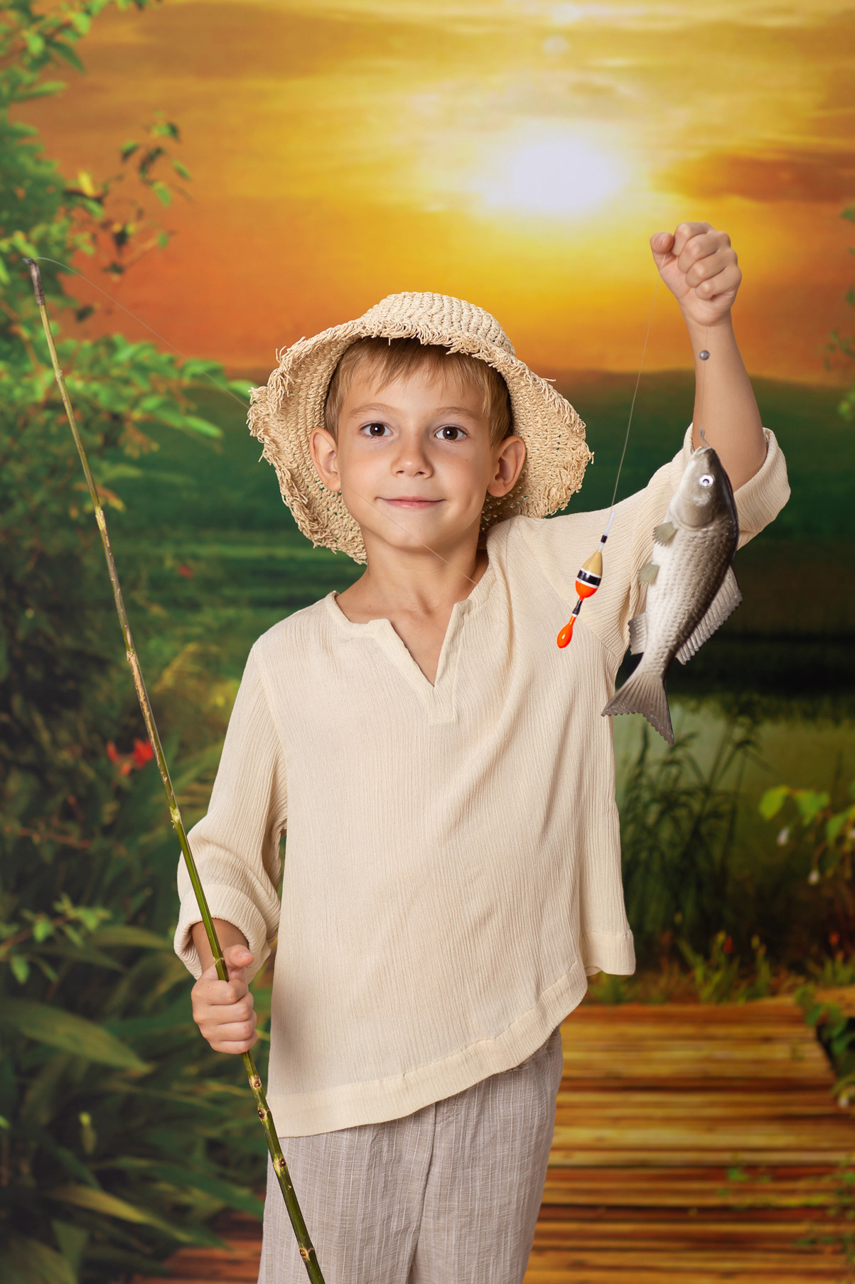 Детская тематическая костюмированная фотосессия Рыбачок. Мальчик показывает свой улов.