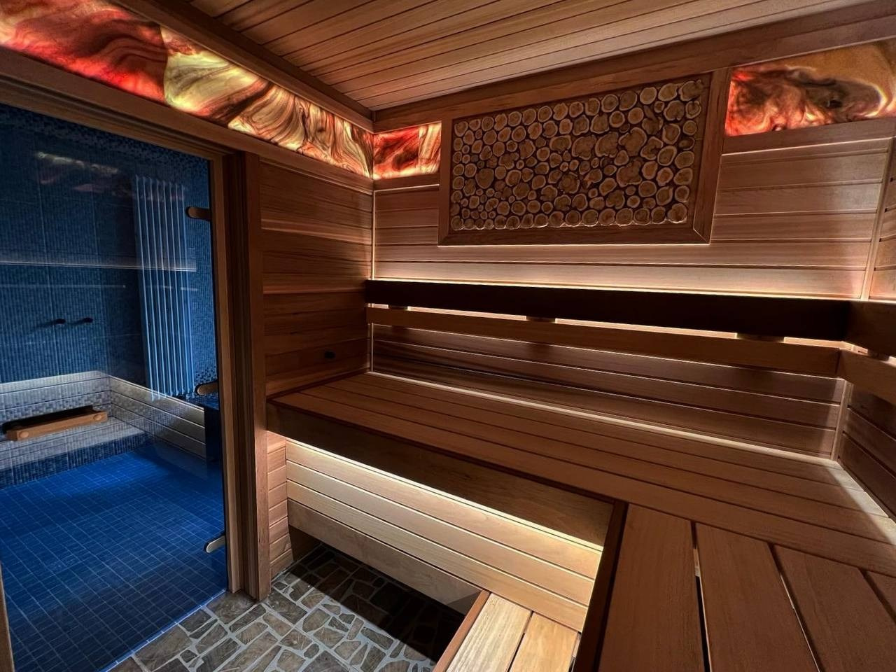 Баня в Сестрорецке, выполненная из кедра и абаша с ониксом, играющим цветом, создаёт тёплую и уютную атмосферу парения. SaunaTopMasters
