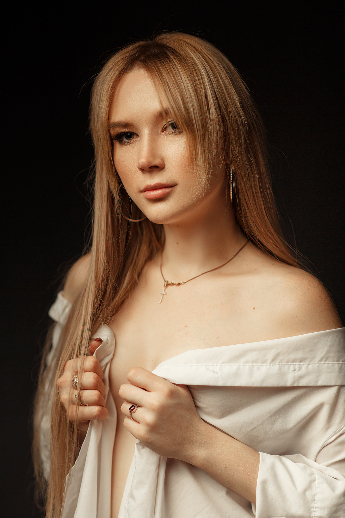женский портрет обнаженной девушки в белой рубашке в темной фотостудии