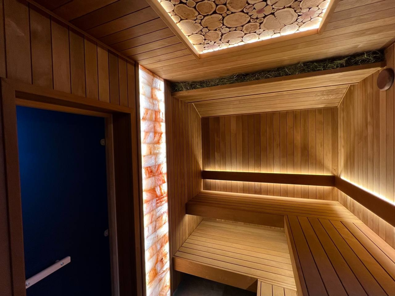 Атмосферная парная в Садах Времени с большим панно из гиммалайской соли, сеном с горных лугов Крыма и теплой линейной подсветкой. SaunaTopMasters