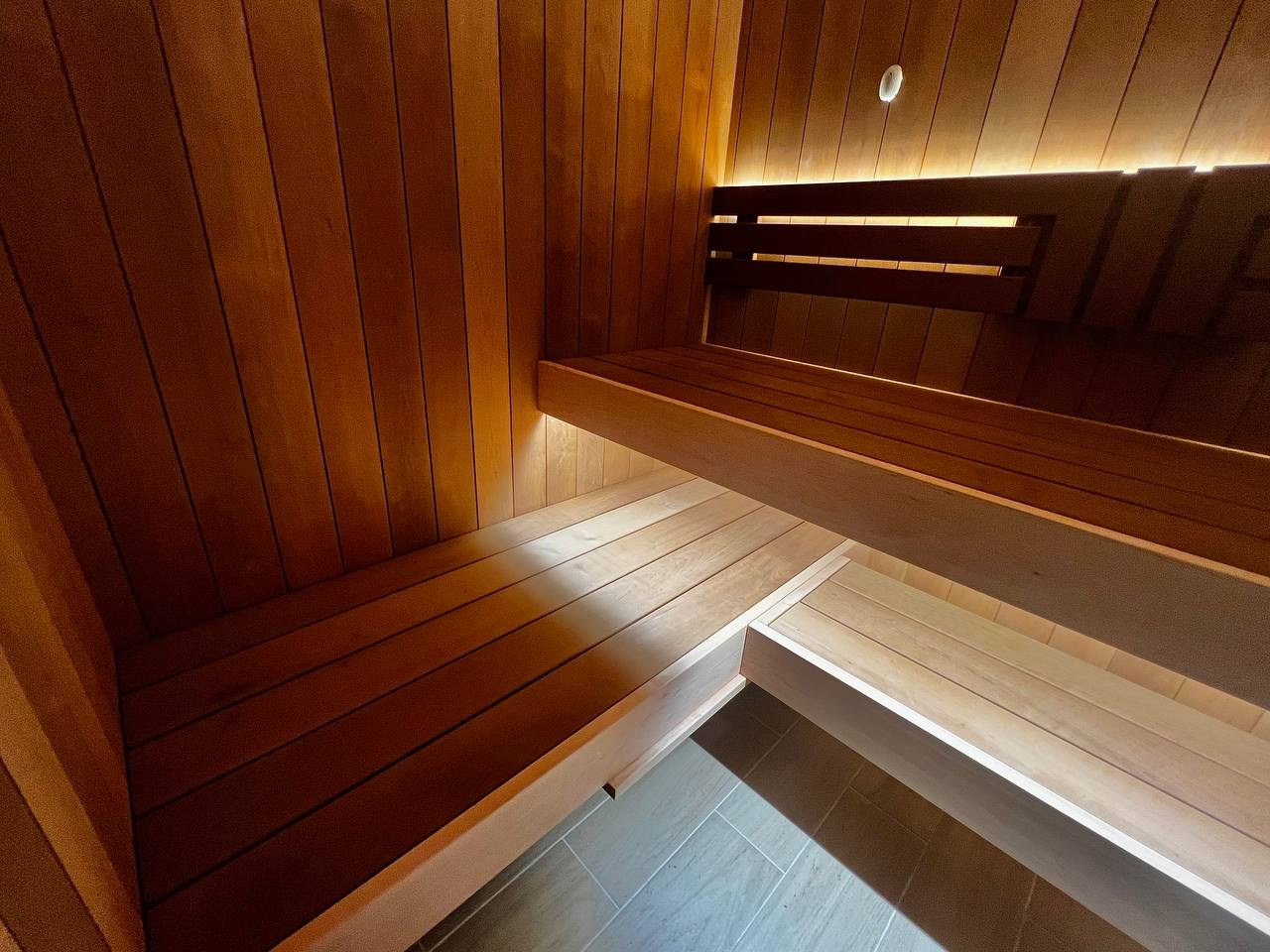 Сауна в Рощино на базе электрокаменки с парогенератором Harvia Virta выполнена из термоольхи с интеграцией световых линий из можжевельника. SaunaTopMasters