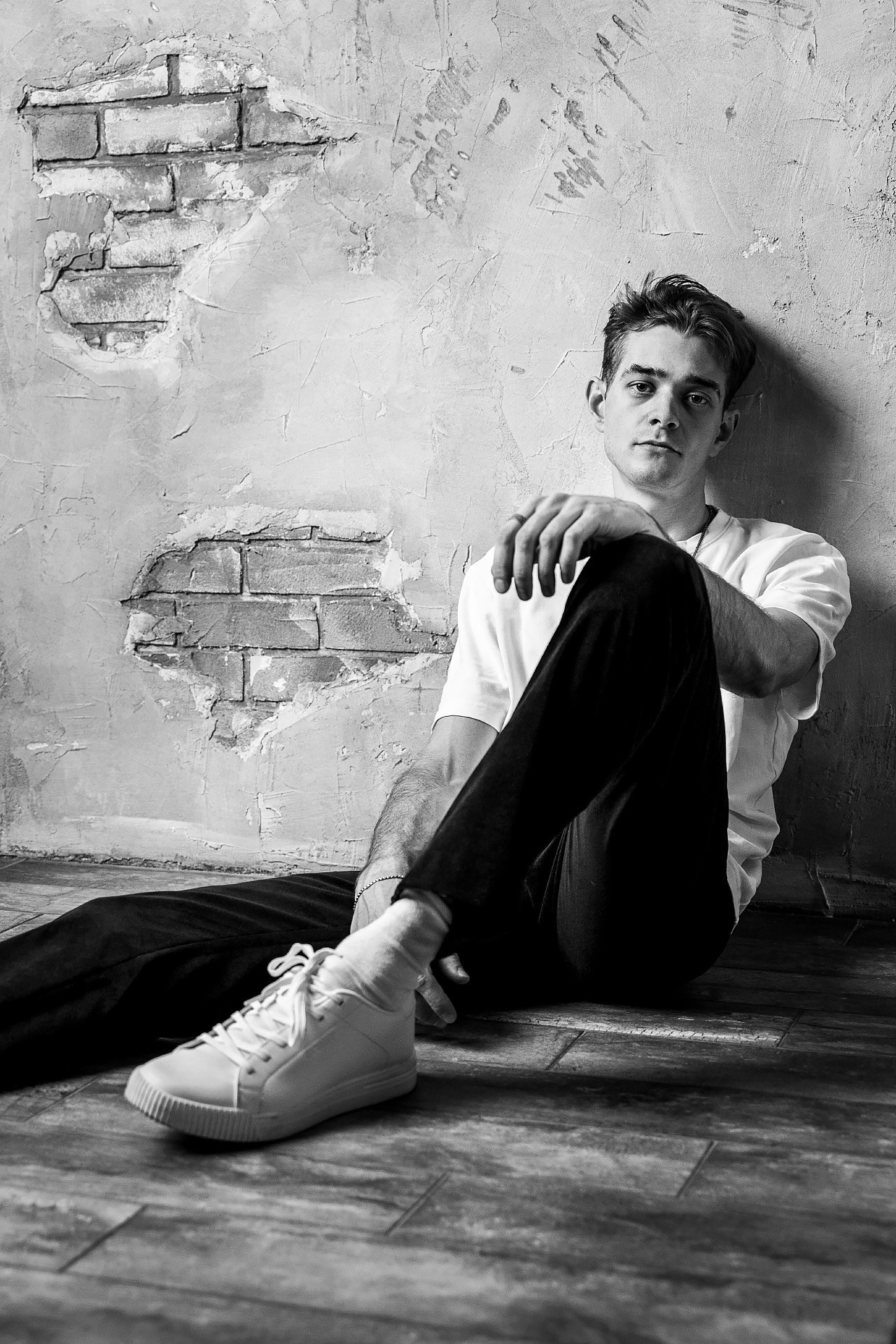 Черно-белая фотография мужчины сидящего на полу