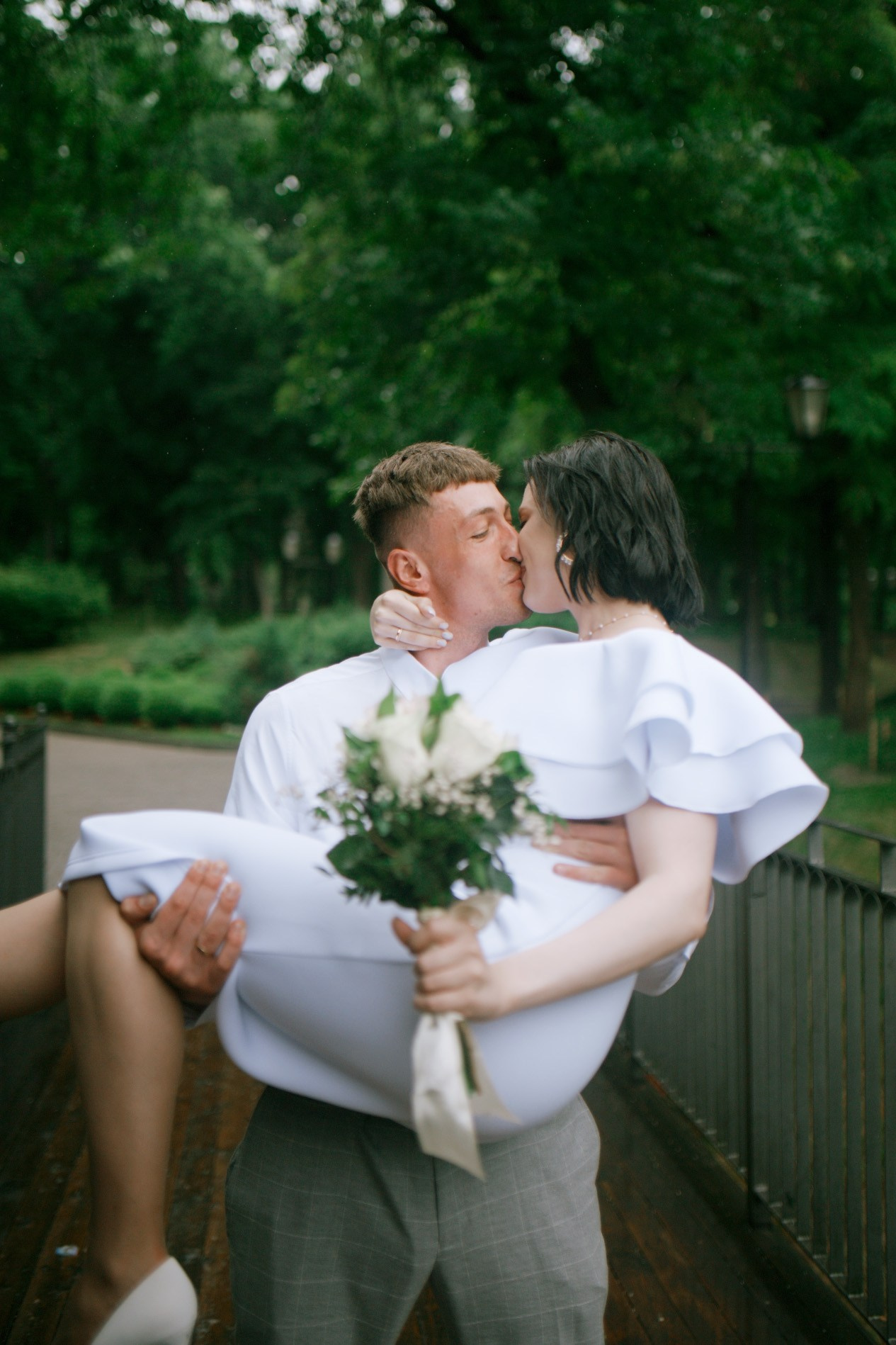 Свадебная съемка на природе — невеста в белом платье на фоне цветущих деревьев