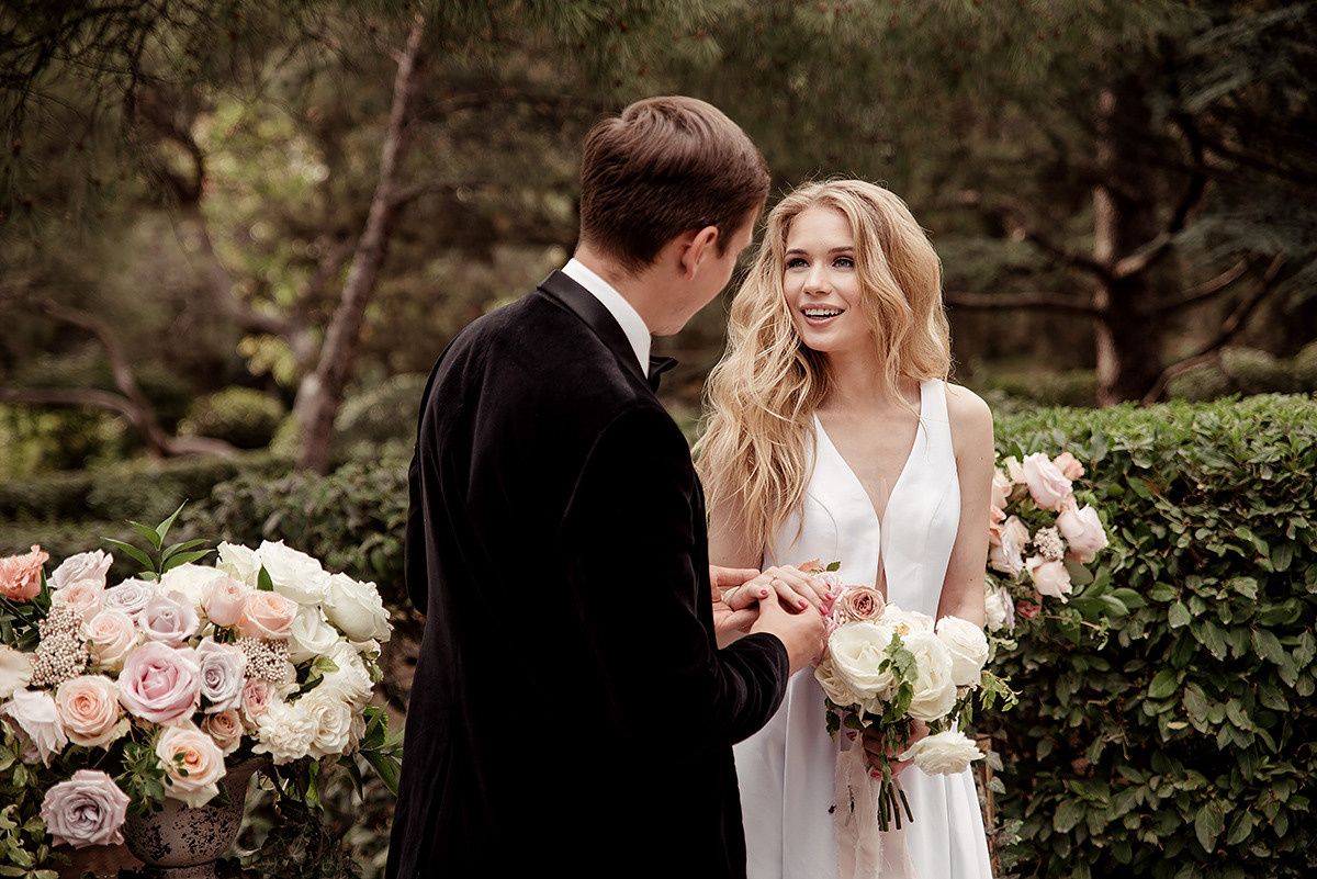 Жених надевает невесте обручальное кольцо.