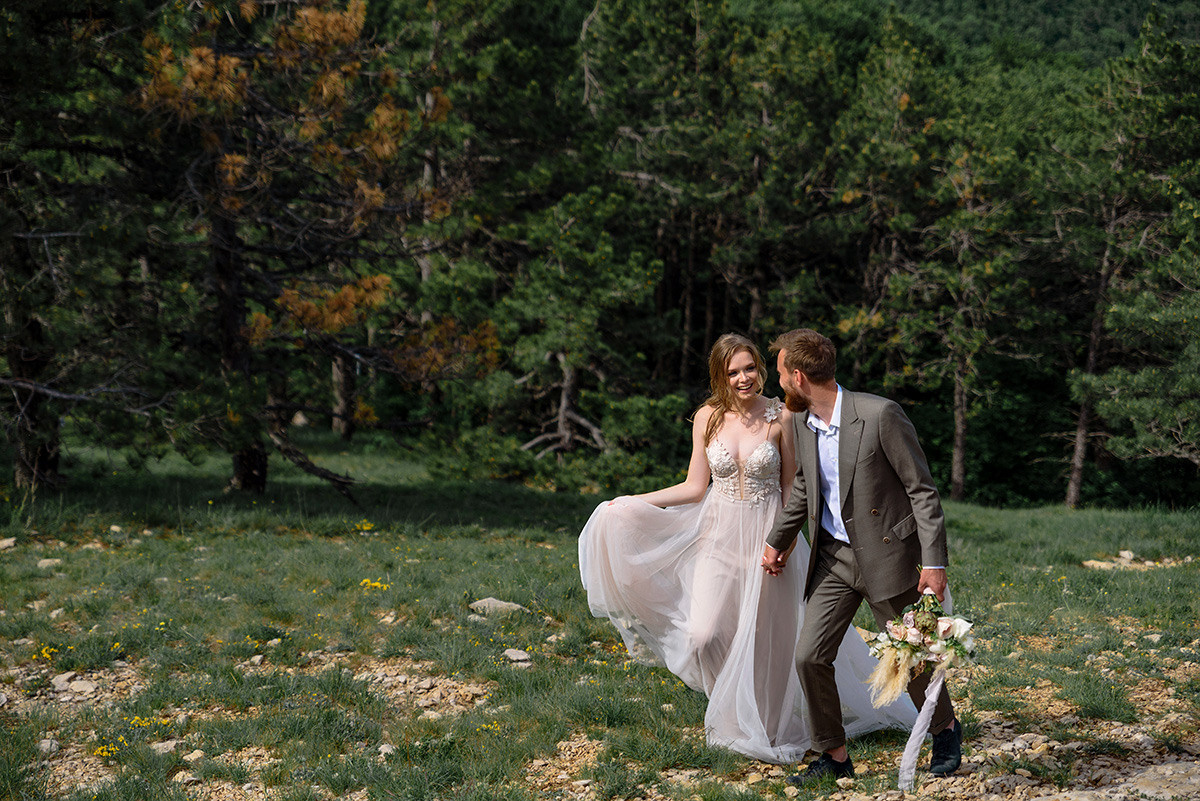 Свадебная прогулка жениха и невесты в лесу.