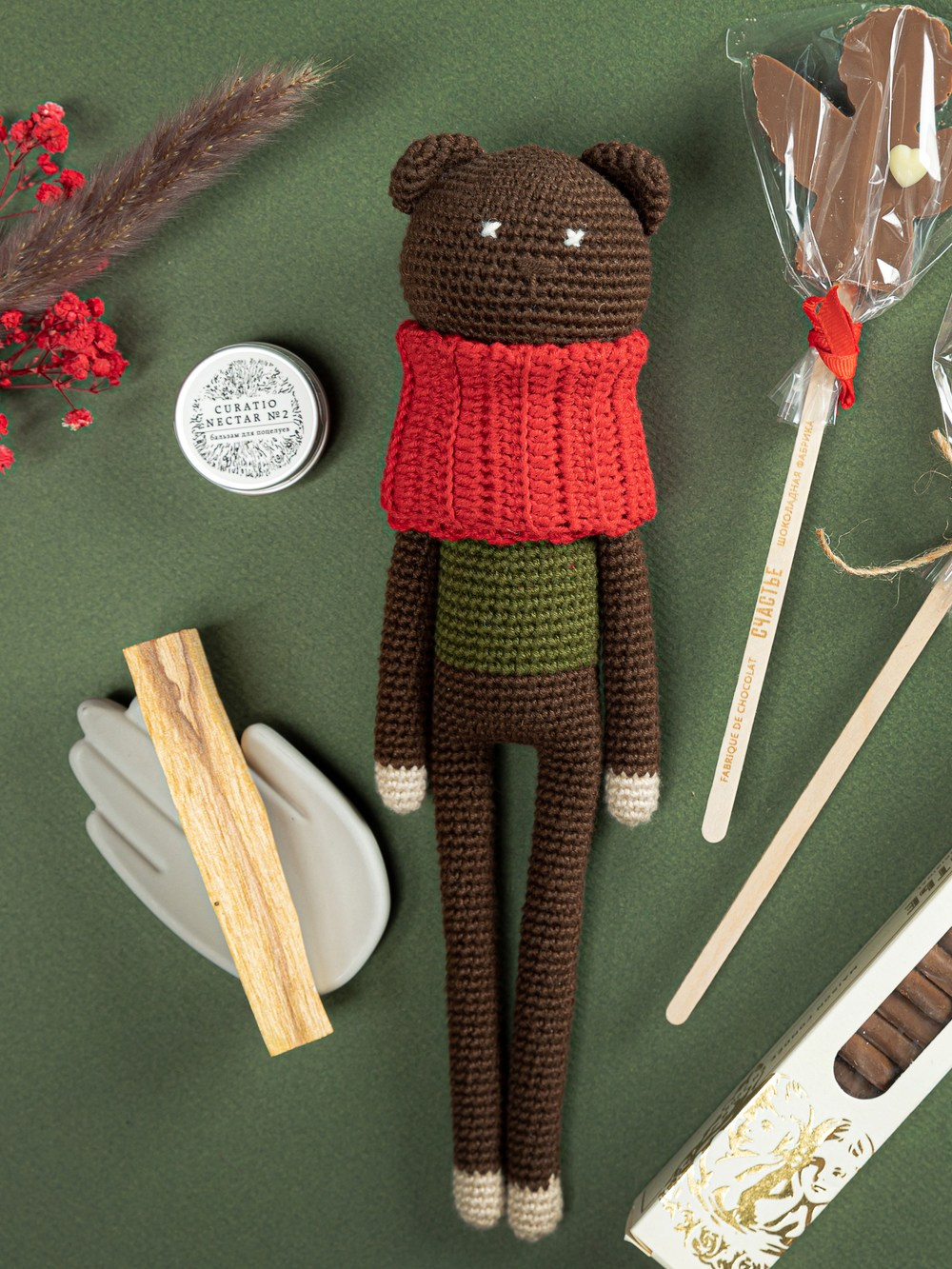 Вязаная игрушка медведь на зеленом фоне