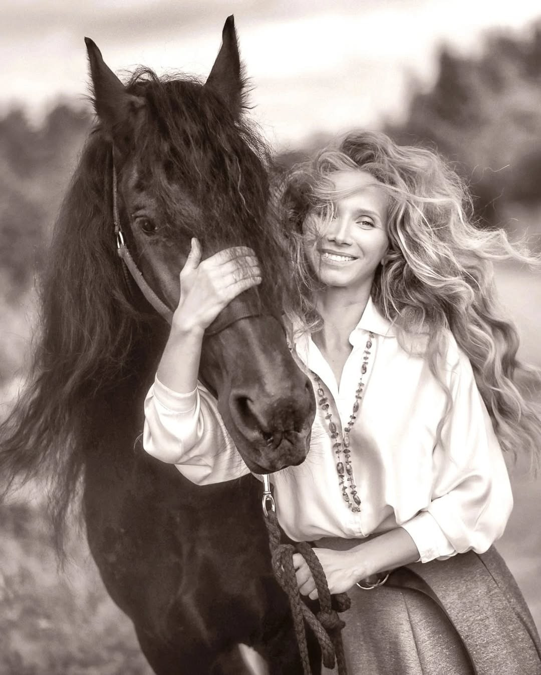 Черно-белый портрет девушки, девушка обнимает своего вороного коня