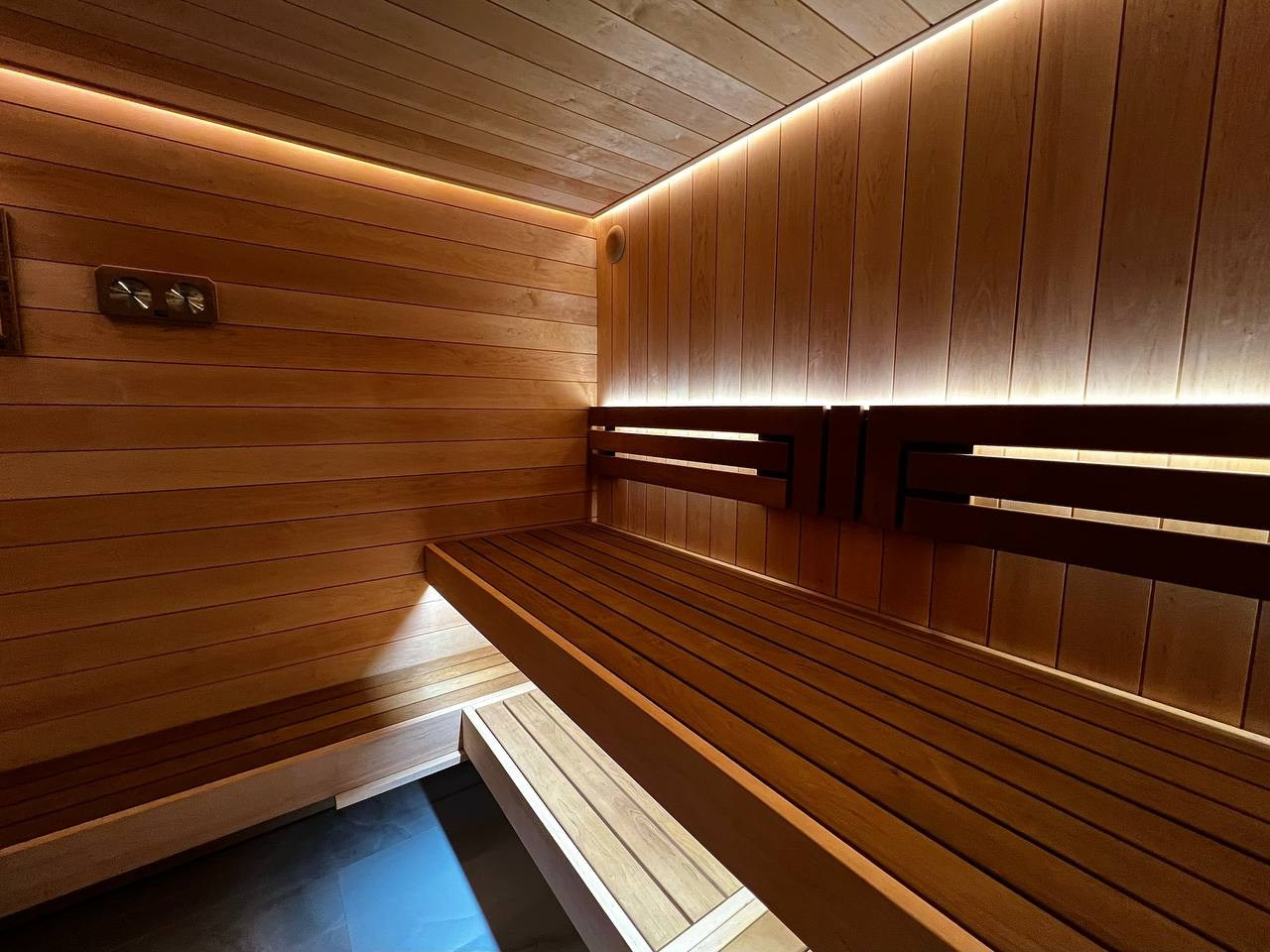 Уютная сауна в КП Новый Мир. В центре внимания- Harvia Cilindro, а закарнизное освещение плавно перетекает в подсветку противопожарного угла. SaunaTopMasters