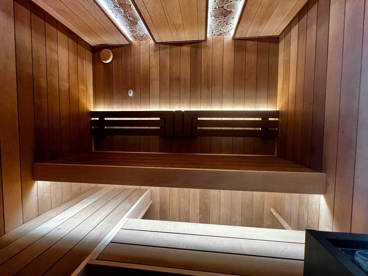 Сауна в Рощино на базе электрокаменки с парогенератором Harvia Virta выполнена из термоольхи с интеграцией световых линий из можжевельника. SaunaTopMasters
