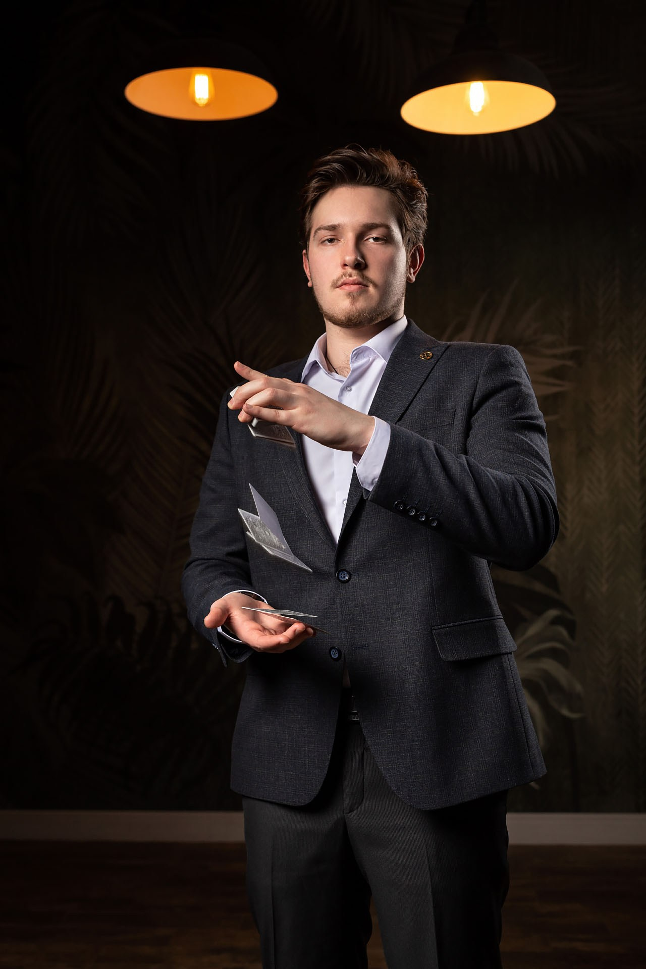 Мужчина в пиджаке с картами в студии