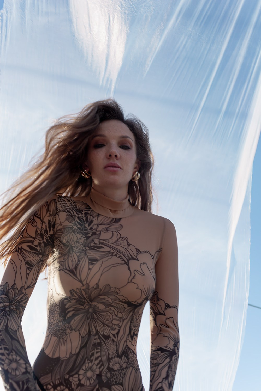 Портрет девушки ракурс снизу в боди на улице на фоне пленки