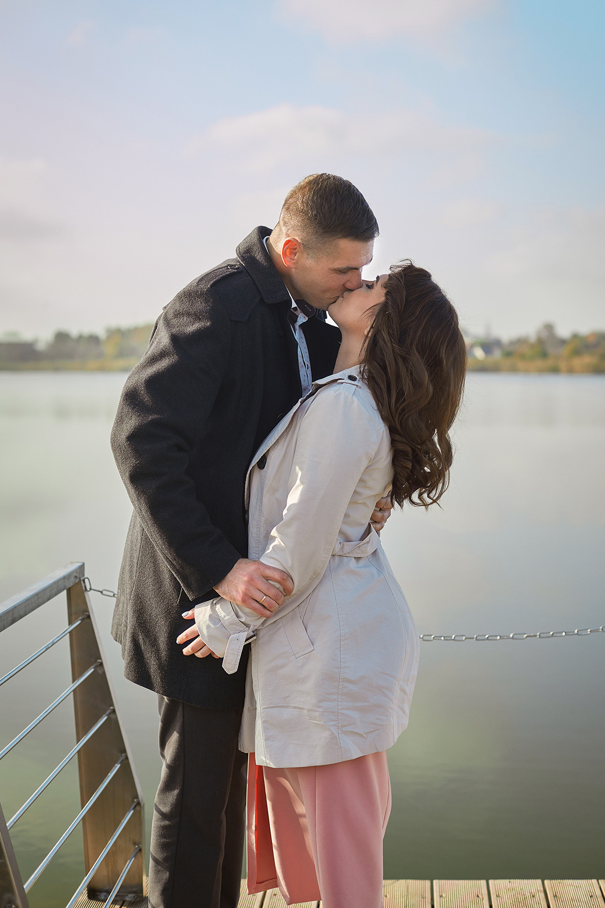 Влюбленная пара целуется на мосту на фоне реки. Фотограф. Тимашевск. Кубань. Краснодарский край.