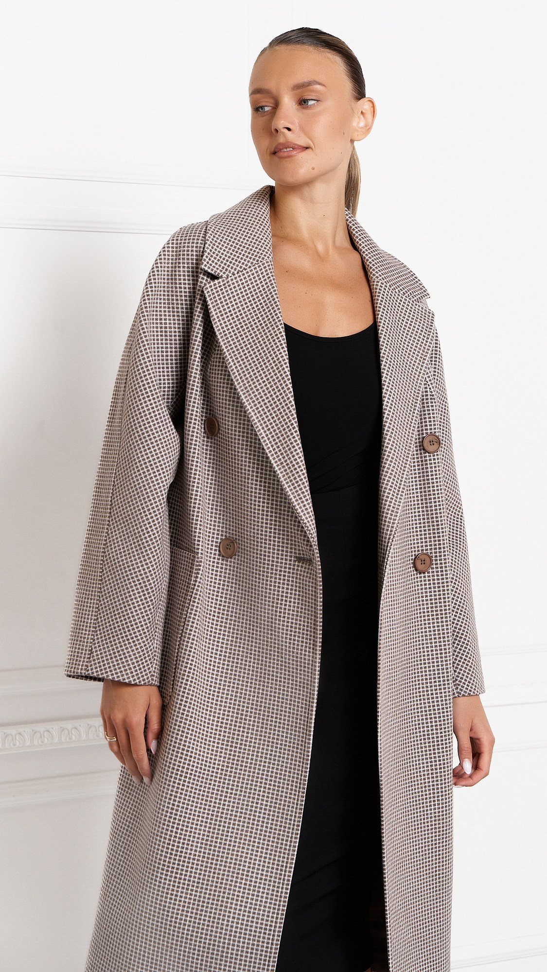 Девушка одета в серое дорогое пальто и позирует