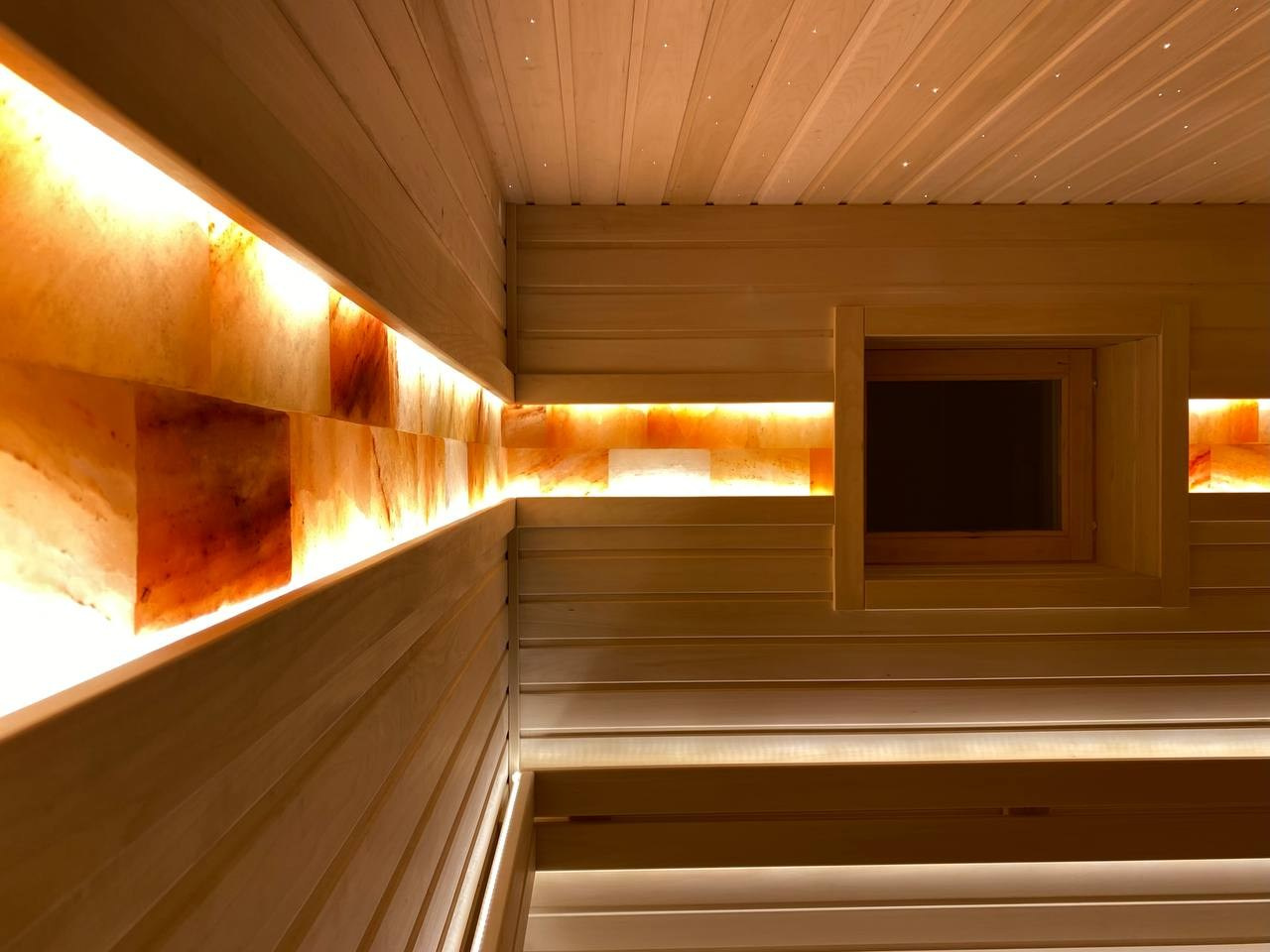 «Белая» баня в Кингисеппе из липы, с двумя световыми зонами: для интимного отдыха под звездами и активного парения в свете солевой линии. SaunaTopMasters