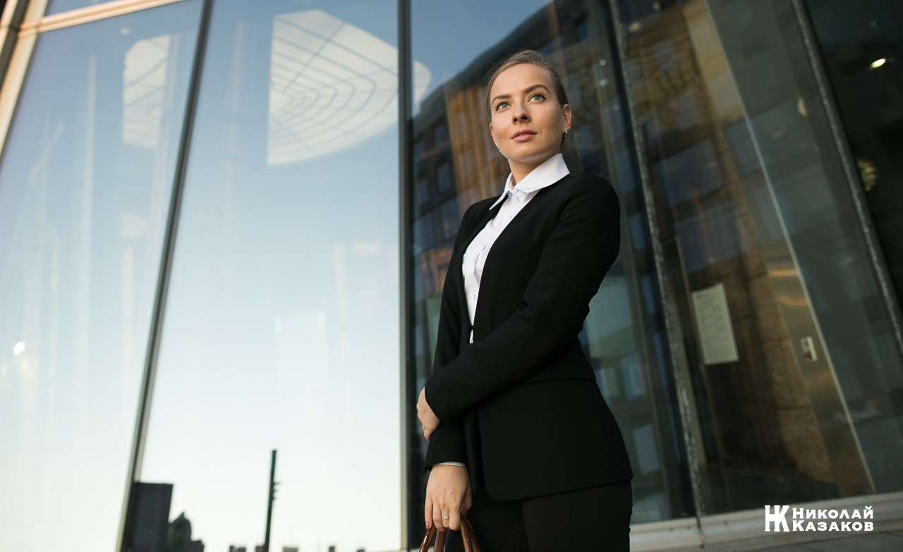 Бизнес портрет красивой женщине на фоне стекол.