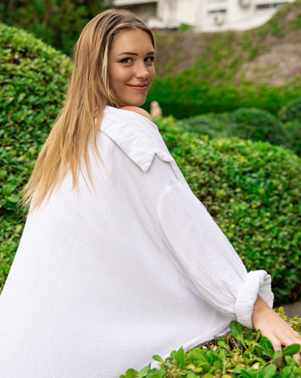 Красивая девушка позирует среди зелёной листвы в Буэнос-Айресе