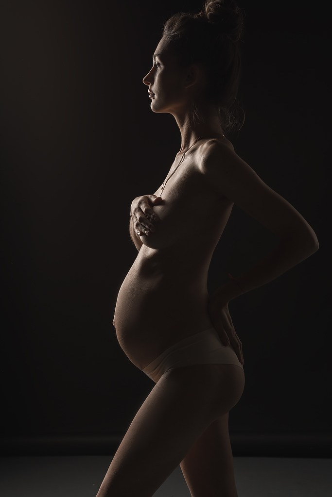 фотосъемка обнаженной беременной женщины, фотосессия в стиле минимализм в фотостудии на фонах в темном ключе, фотография беременной женщины