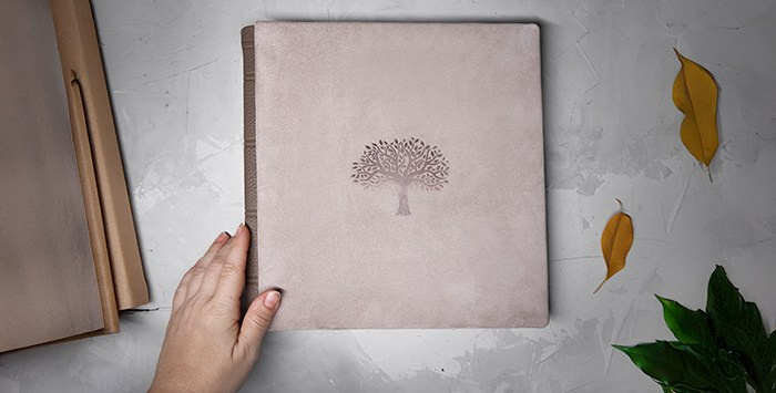 Процесс демонстрации кожаной фотокниги: тактильная обложка с тиснением «Древо жизни».