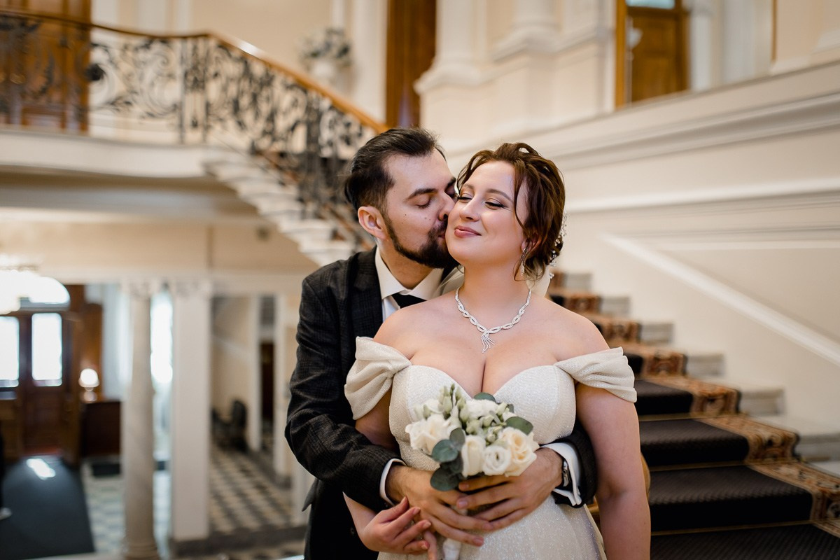 Жених и невеста обнмаются на лестнице в ЗАГСе на фурштатской СПб.