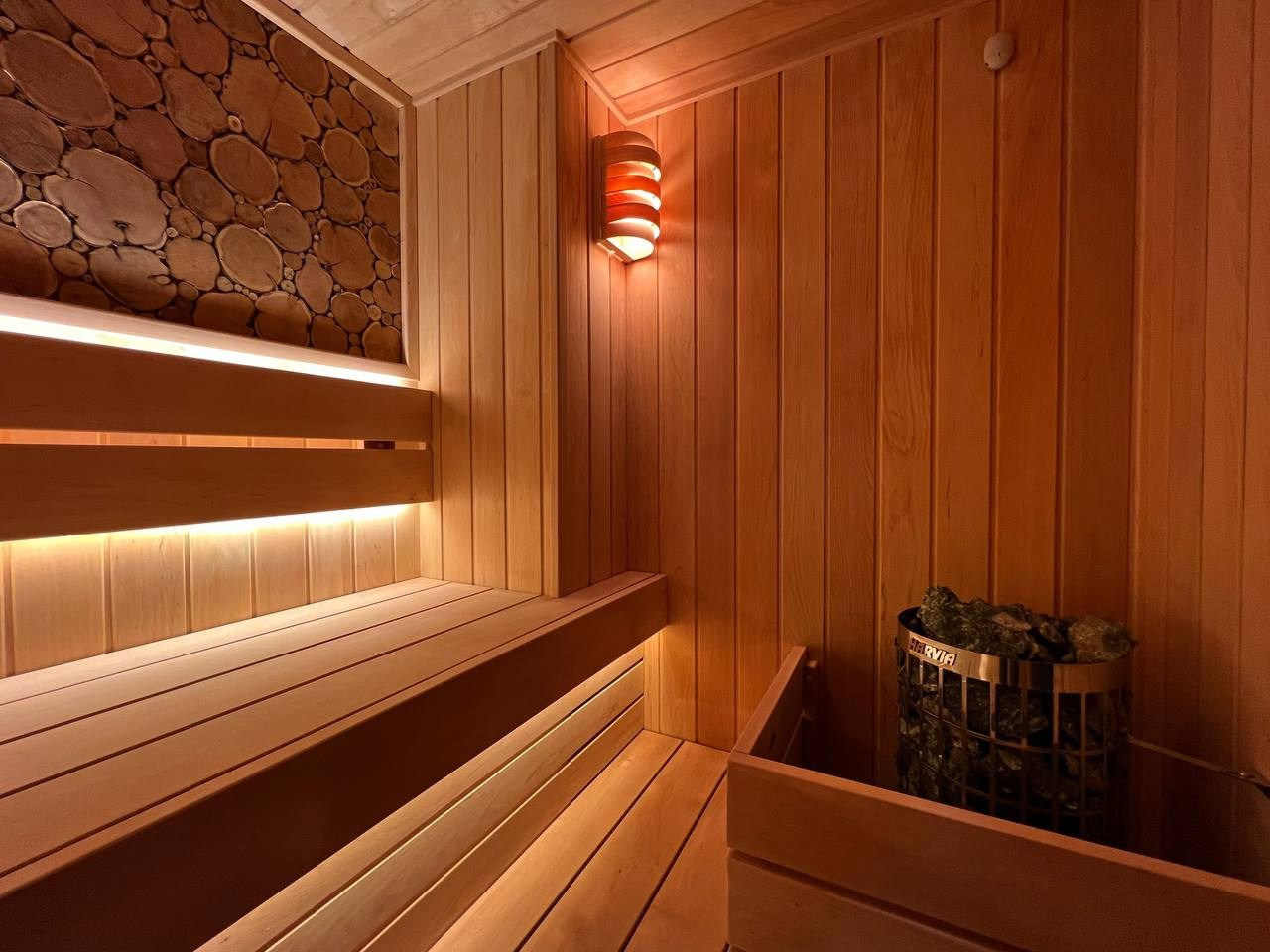 Уютная сауна на Петроградке из белорусской ольхи с можжевеловым панно, винтажными светильниками и паром от Harvia Cilindro. SaunaTopMasters