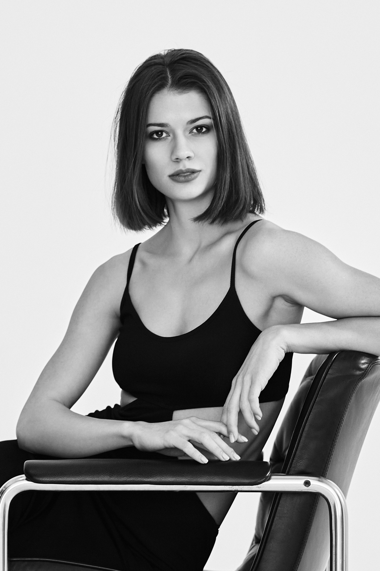 Темноволосая красавица Софья Мисс Тула — 2020 в студии на светлом фоне в рубашке или ярком наряде.