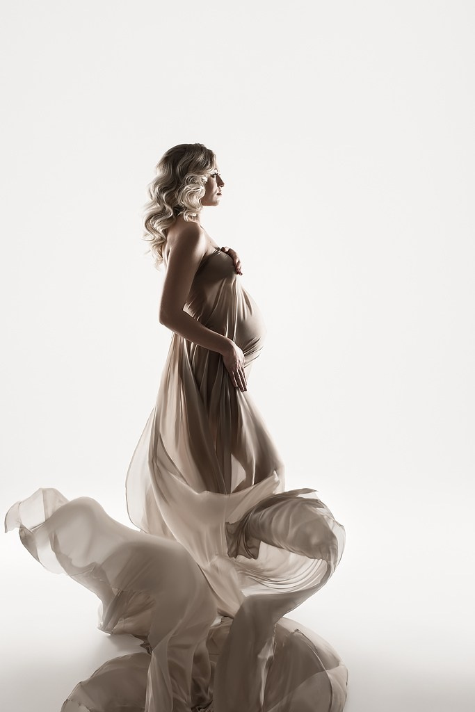 фотосессия беременной в фотостудии на светлом фоне в красивом разлетающемся платье, фотография беременности, фотосессия беременных, портрет беременной