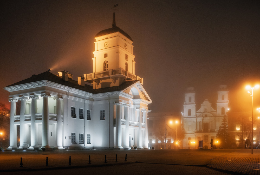 Minsk, Belarus. The View of the Town Hall and Cathedral of the Holy Name of Mary in the fog at night.