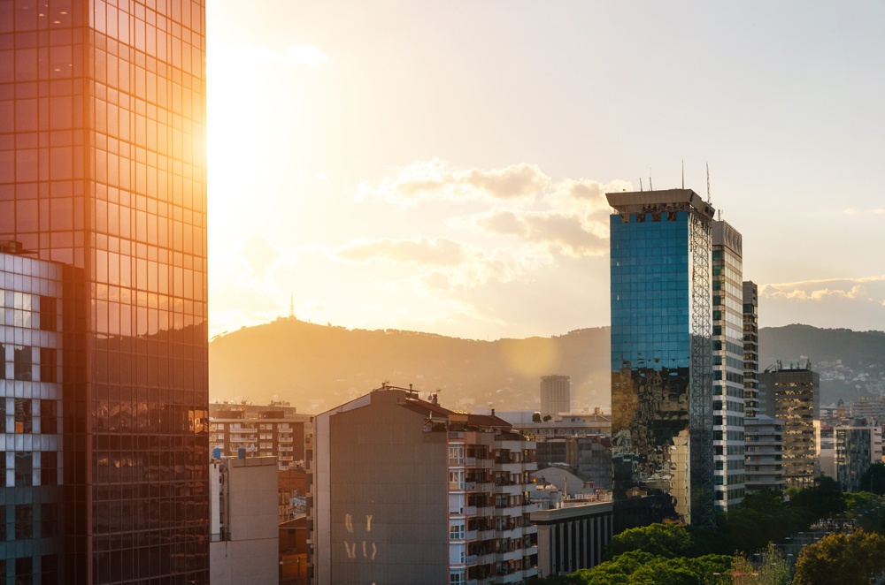 The View of glass skyscrapers with reflection on Carrer de Tarragona Street near Spain square at sunset. Barcelona, Catalonia, Spain.
