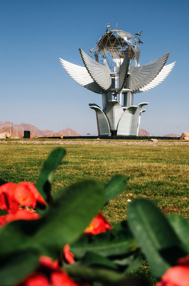 Sharm el Sheikh, Sinai, Egypt. The Monument Peace Square on the background of red flowers.