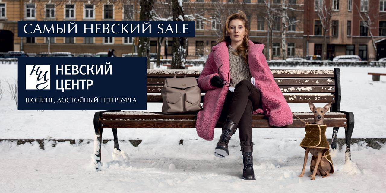 Модная женщина сидит на скамейке зимой с собакой