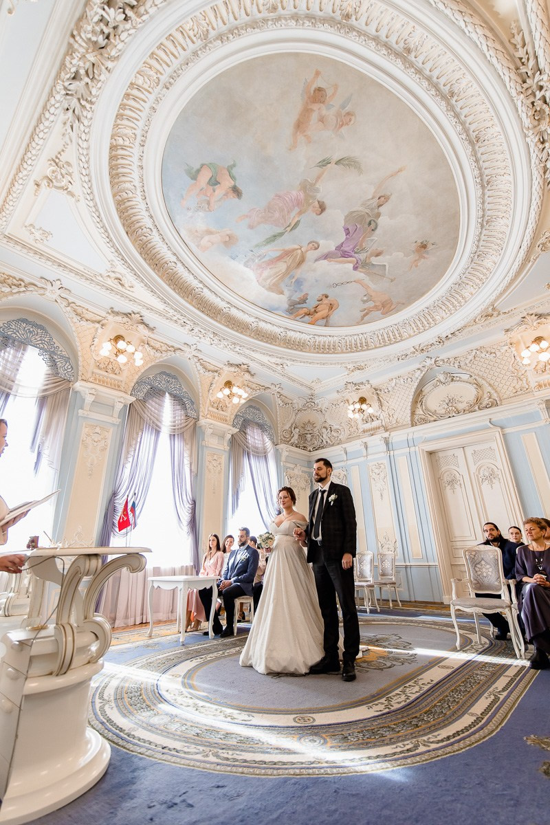 Жених и невеста в зале регистраций в ЗАГСе на фурштатской СПб. Вертикальный кадр