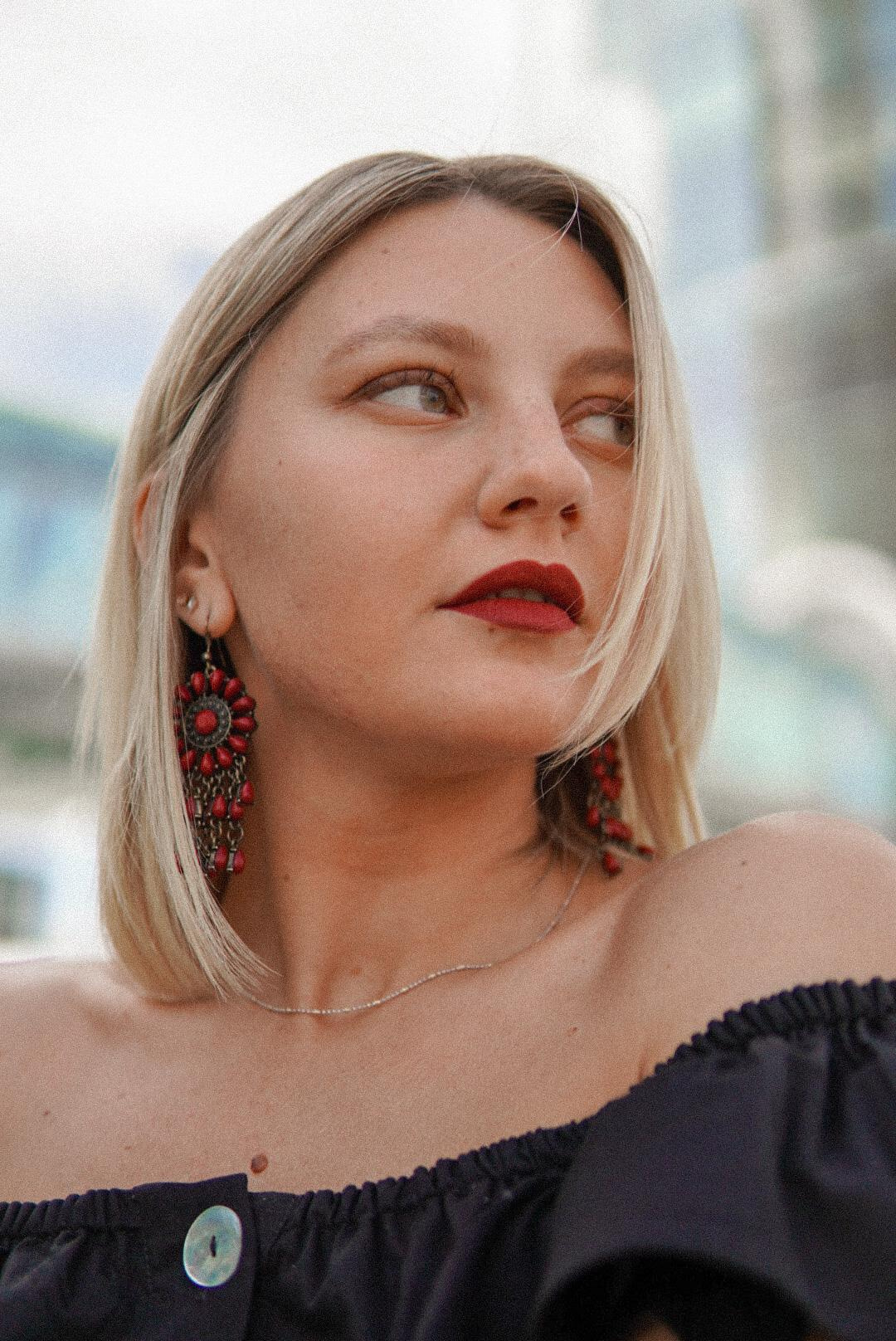 Девушка со светлым каре в черной блузке смотрит в правую сторону