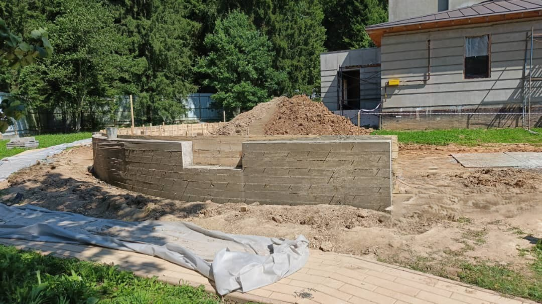 Заливка подпорной стенки из бетона — укрепление склона участка.