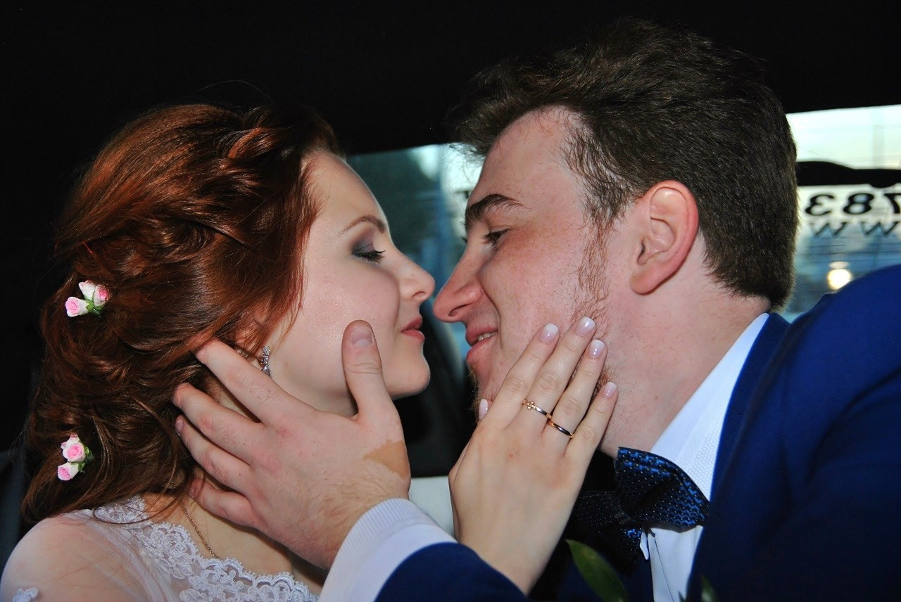 Свадебная фотосъёмка летом, новобрачные лицом к лицу крупным платом в автомобиле, в машине, в лимузине