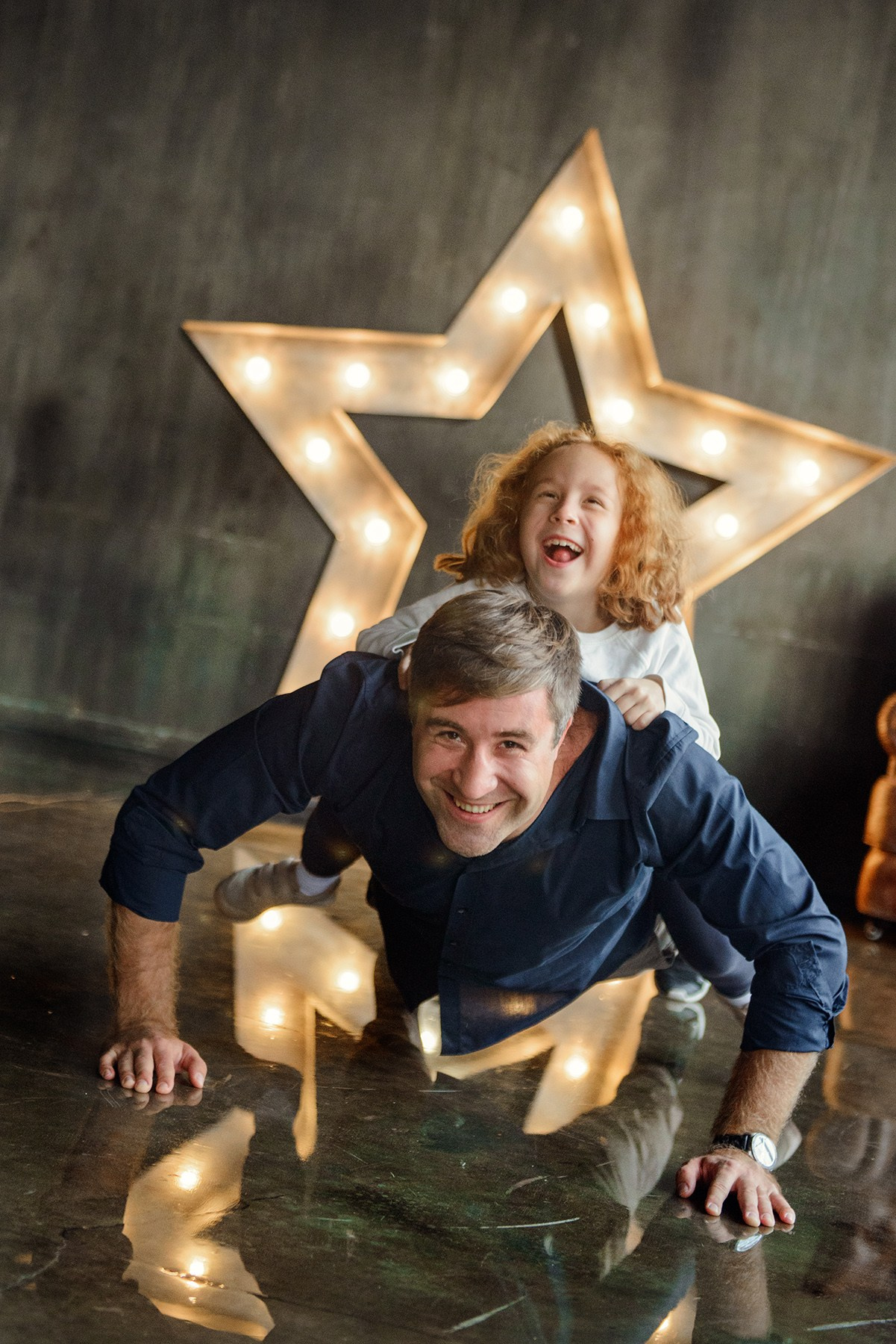 dad and daughter in a dark photo studio
