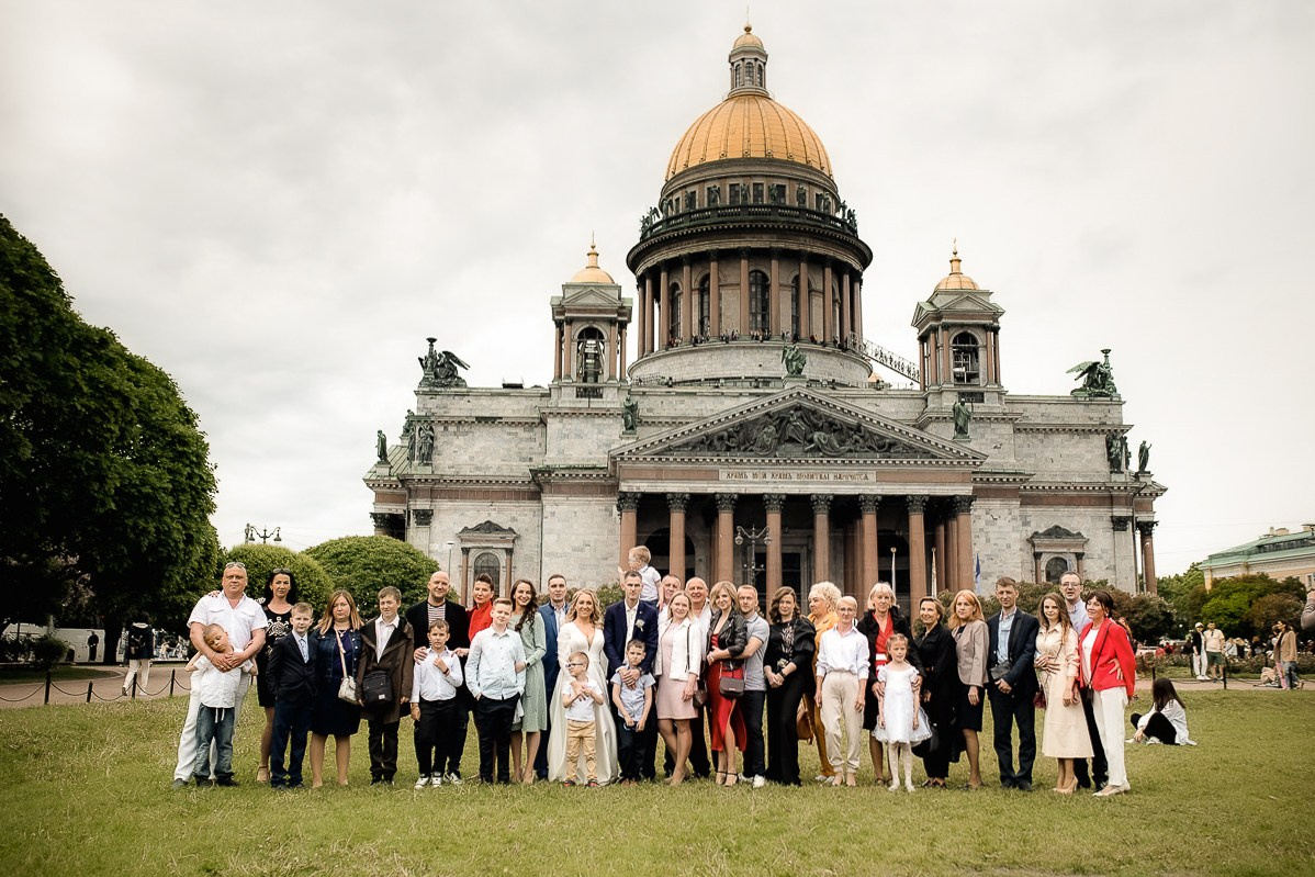 Общая фотография молодожёнов с гостями на фоне Исаакиевского собора в Санкт-Петербурге