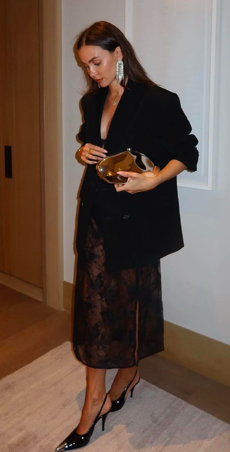 Идеи образов для женщин на Новый год 2026 — стильные праздничные комплекты и трендовые наряды. elegantnyj-obraz-Chernyj-dvubortnyj-pidzhak-kruzhevnaya-yubka-midi-i-zolotistyj-klatch