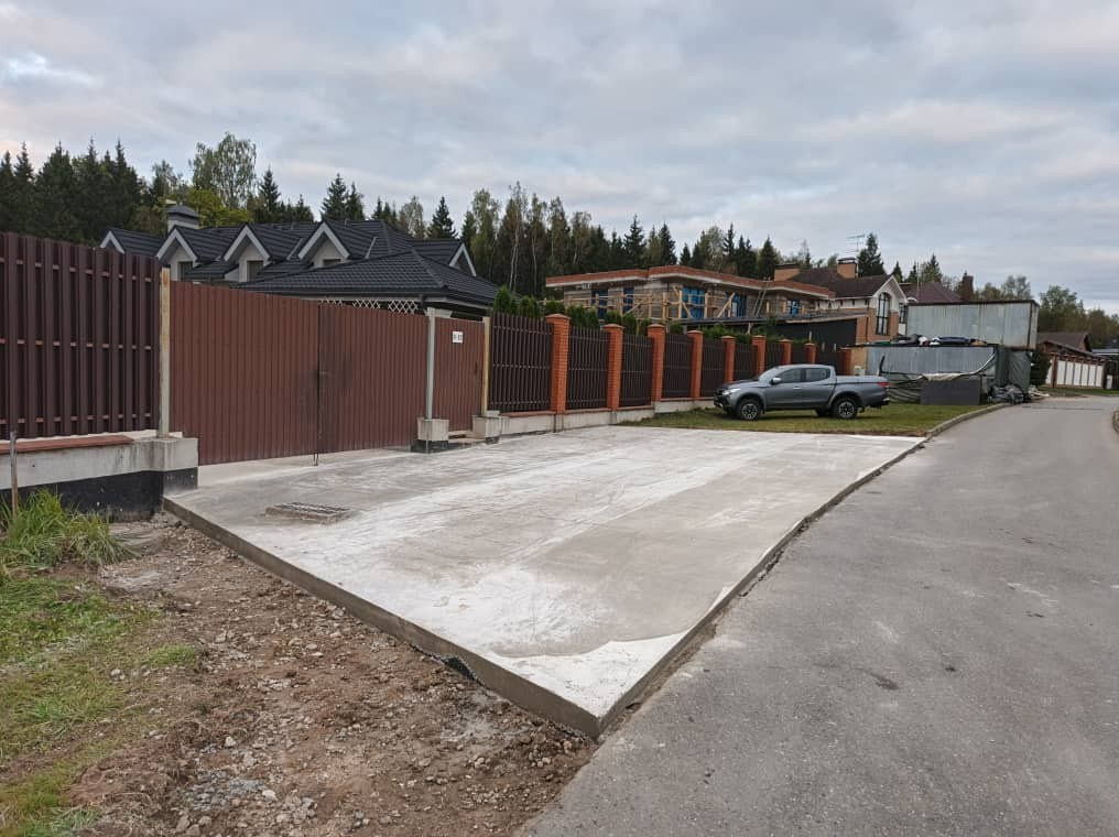 Общий вид участка с домом и бетонными дорожками — строительство в Подмосковье