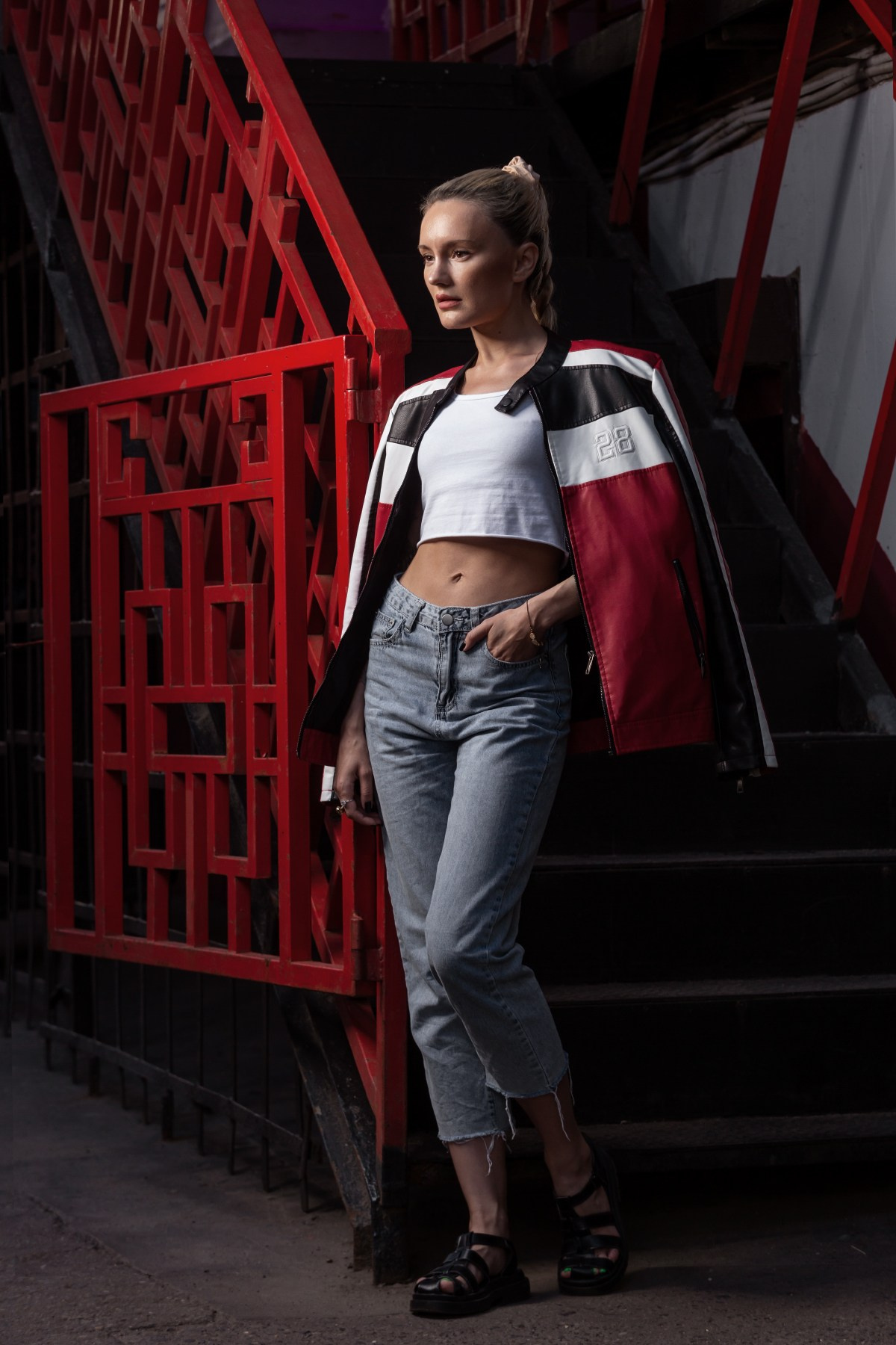 Девушка в кожаной куртке у красного забора, фабрика "Красный Октябрь"