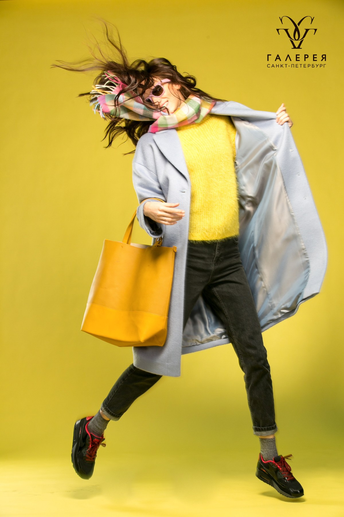модель в прыжке в пальто на жёлтом фоне в тц галерея