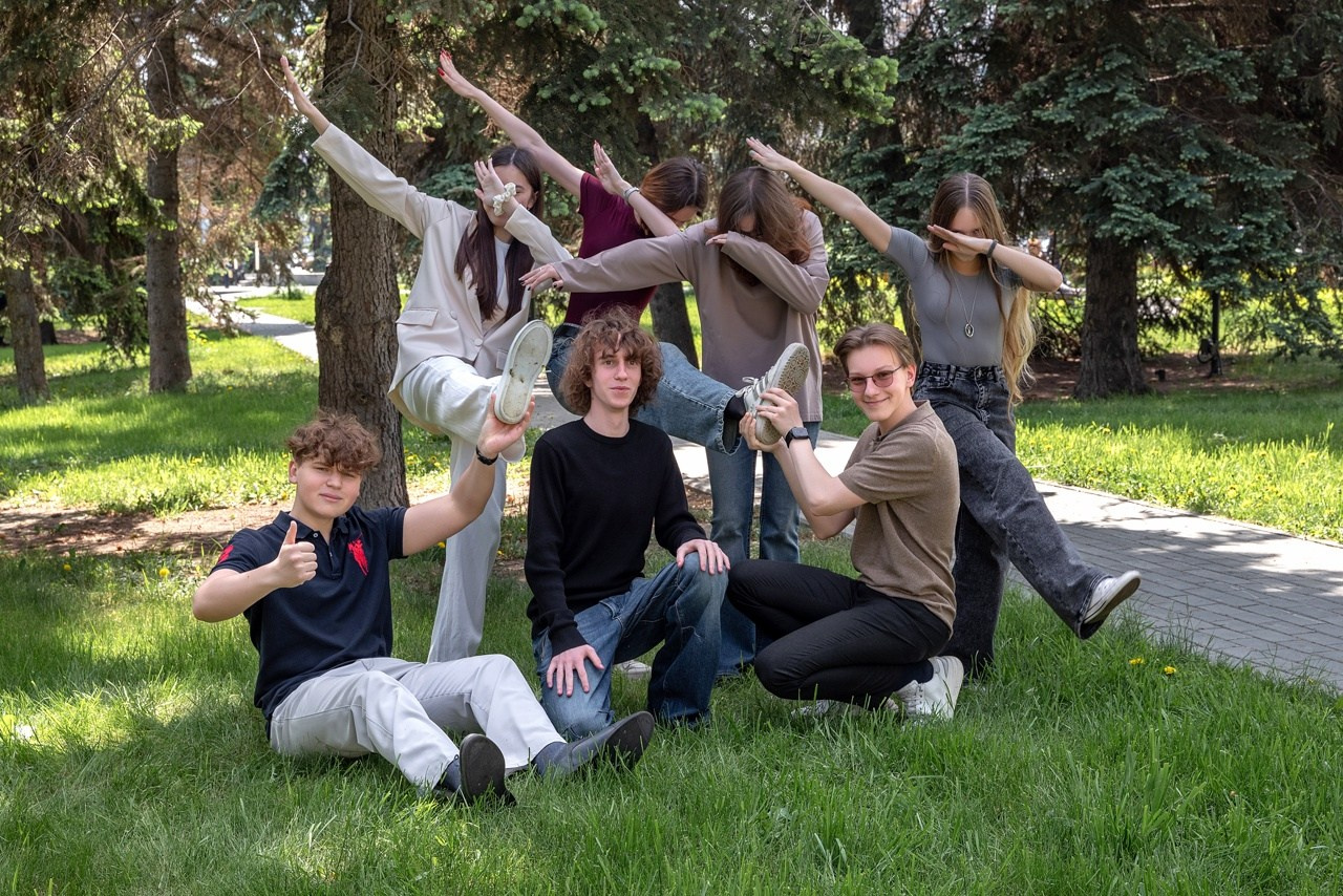 Старшеклассники взмыли руки к небу чтобы круто получится на фото.