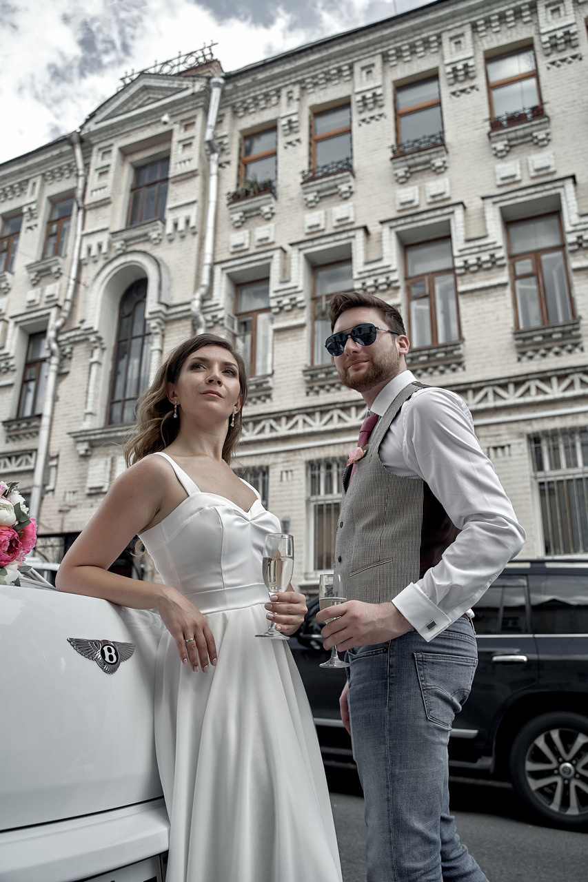 молодожены на фоне красивого здания  возле автомобиля бентли  Свадебная фотосъемка в Москве. Свадебный фотограф в Москве  Сергей Гаварос.