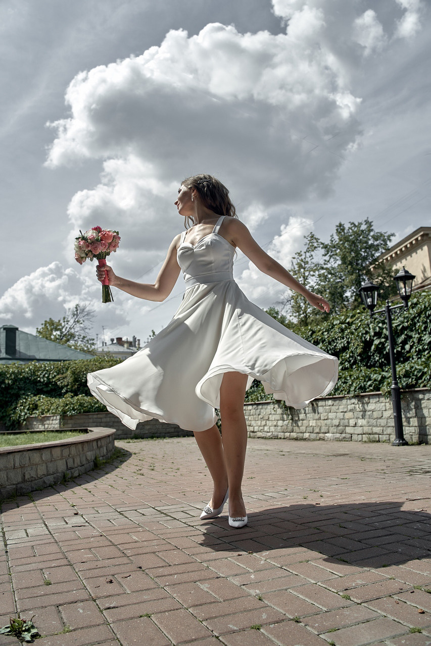 невеста с букетом кружится в коротком платье  Свадебная фотосъемка в Москве. Свадебный фотограф в Москве  Сергей Гаварос.