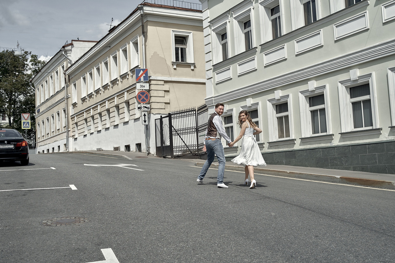 молодожены бегут по улочке Китай-города невеста заигрывает с женихом на улице Свадебная фотосъемка в Москве. Свадебный фотограф в Москве  Сергей Гаварос.