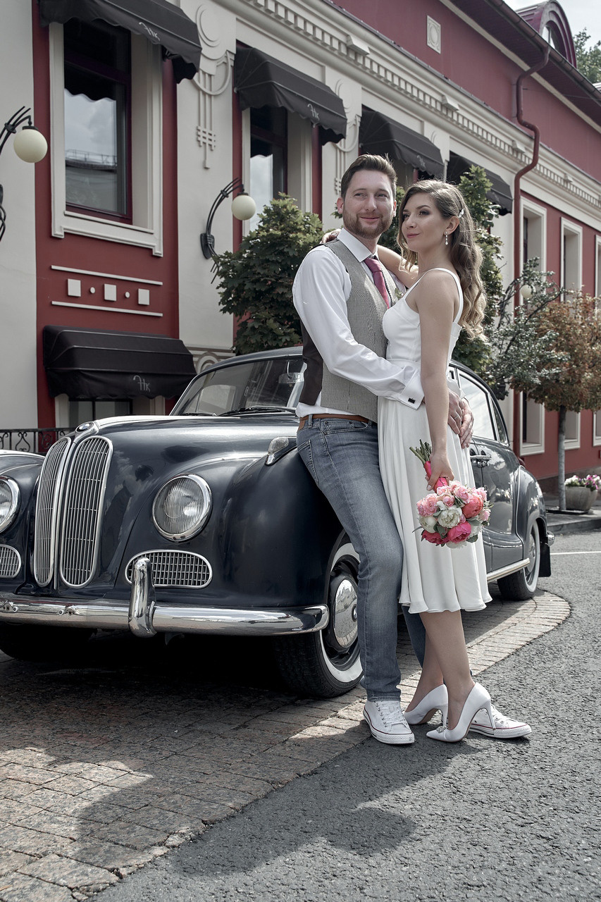 молодожены позируют обнявшись возле шикарного автомобиля Свадебная фотосъемка в Москве. Свадебный фотограф в Москве  Сергей Гаварос.